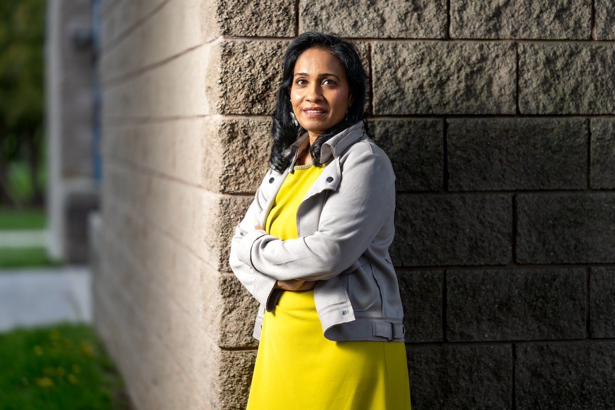 Sharmina Nasrin standing outdoors in a yellow dress, arms crossed